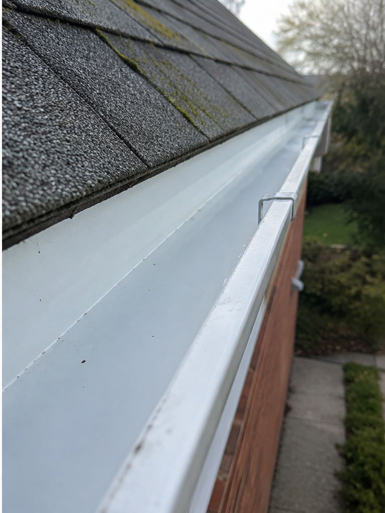 Clean gutter after professional gutter cleaning with debris removed and clear rainwater flow